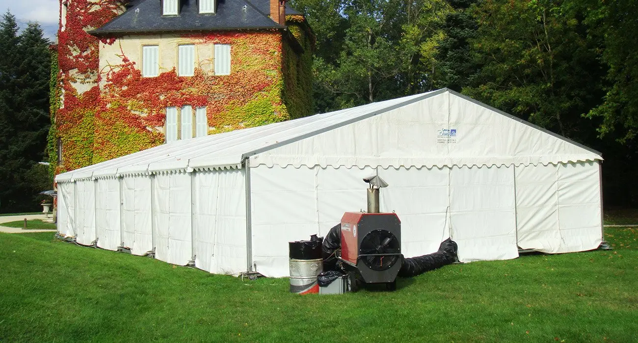 Générateur d’air chaud installé devant une grande tente de réception