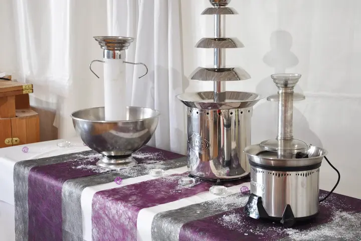 Fontaines à chocolat et à champagne exposées sur une table nappée