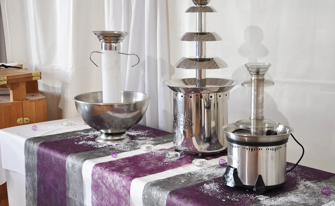 Fontaines à chocolat et à champagne exposées sur une table nappée