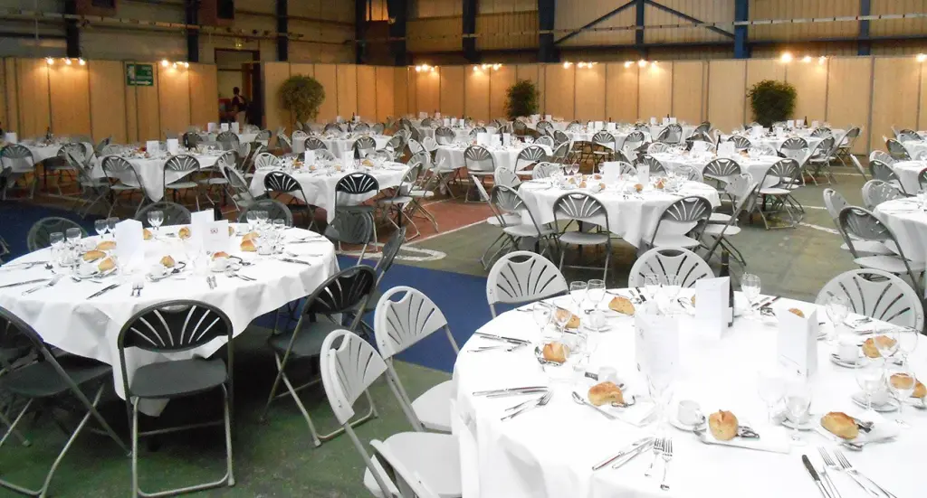 Salle dressée de tables rondes pour un repas de 1 200 convives